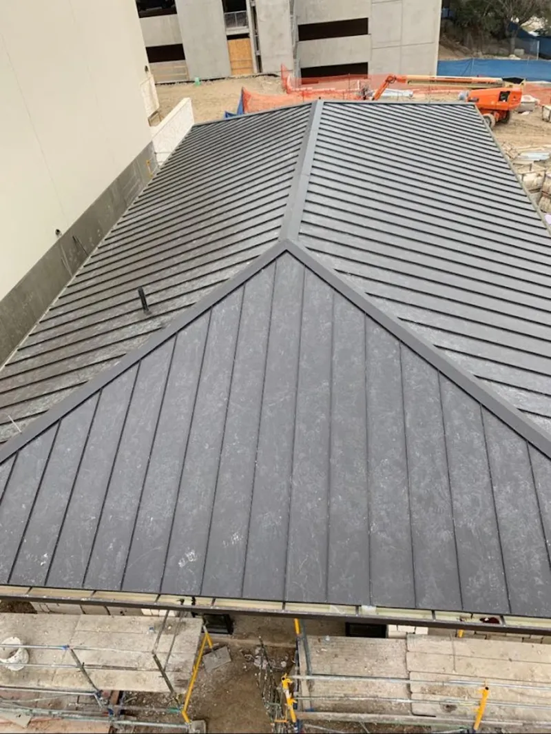 Commercial metal roof construction with crane equipment in Ripley